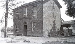 <b>Caption:</b>  Brick house near Danville abandoned on account of danger by room-and-pillar mining of a 6-foot coal at a depth of about 200 feet.<br><b>Credit:</b>  Illinois State Geological Survey<br><b>Date:</b>  Pre-1914<br><b>Library No.:</b>  M-1010